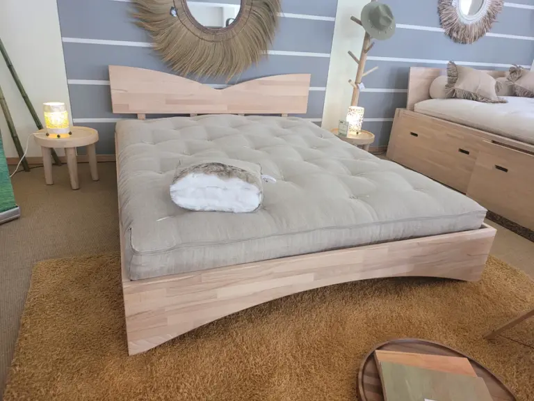 Materasso naturale in cotone e lino visto frontalmente, appoggiato su una struttura letto in legno.