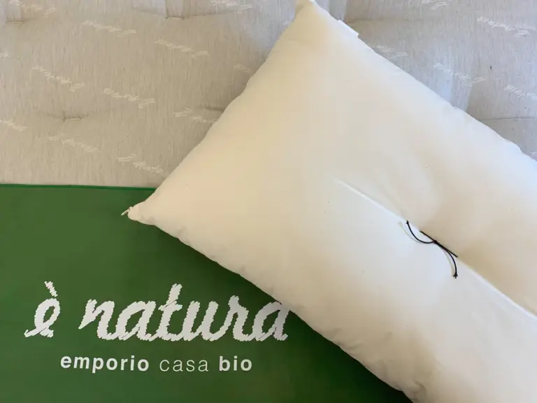 Cuscino in kapok sopra un futon, evidenziando la leggerezza e la naturalezza dei materiali.